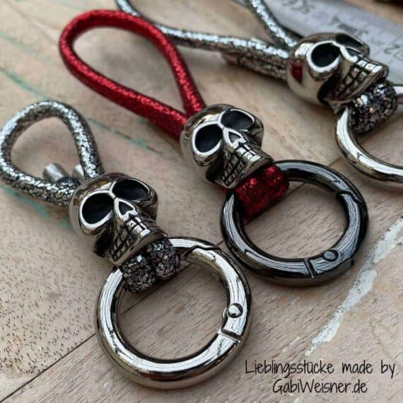 Schlüsselanhänger mit Skull. Leder in verschiedenen Längen und in 3 Farben. Bestückt mit hochwertigem Totenkopf, Ring-Karabiner und Edelstahl-Endkappen.